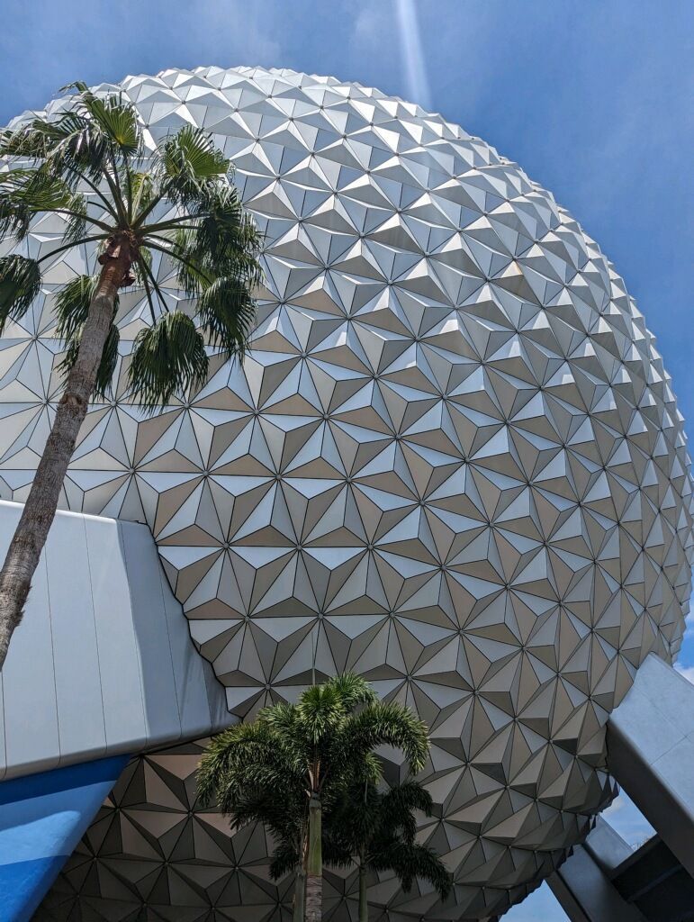 A palm tree is standing in front of a large dome