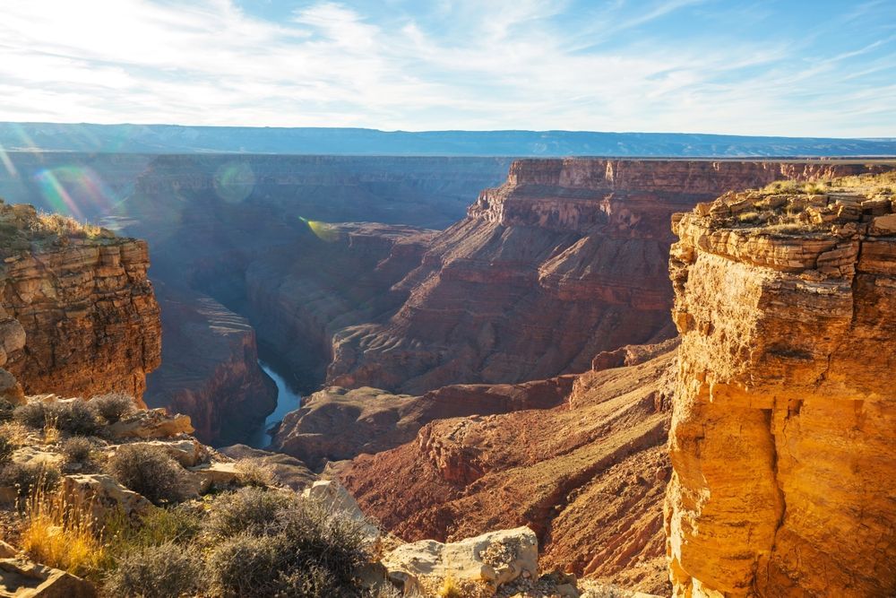 A view of the grand canyon from a cliff with a river running through it.