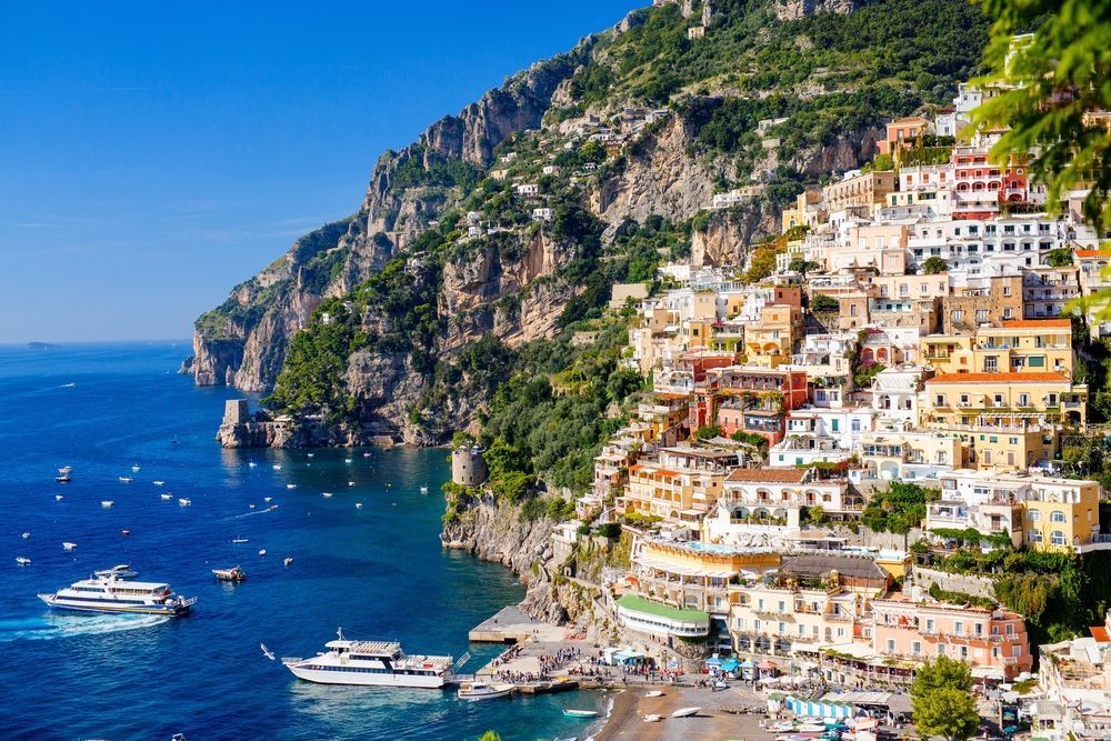 An aerial view of a small town on a cliff overlooking the ocean.