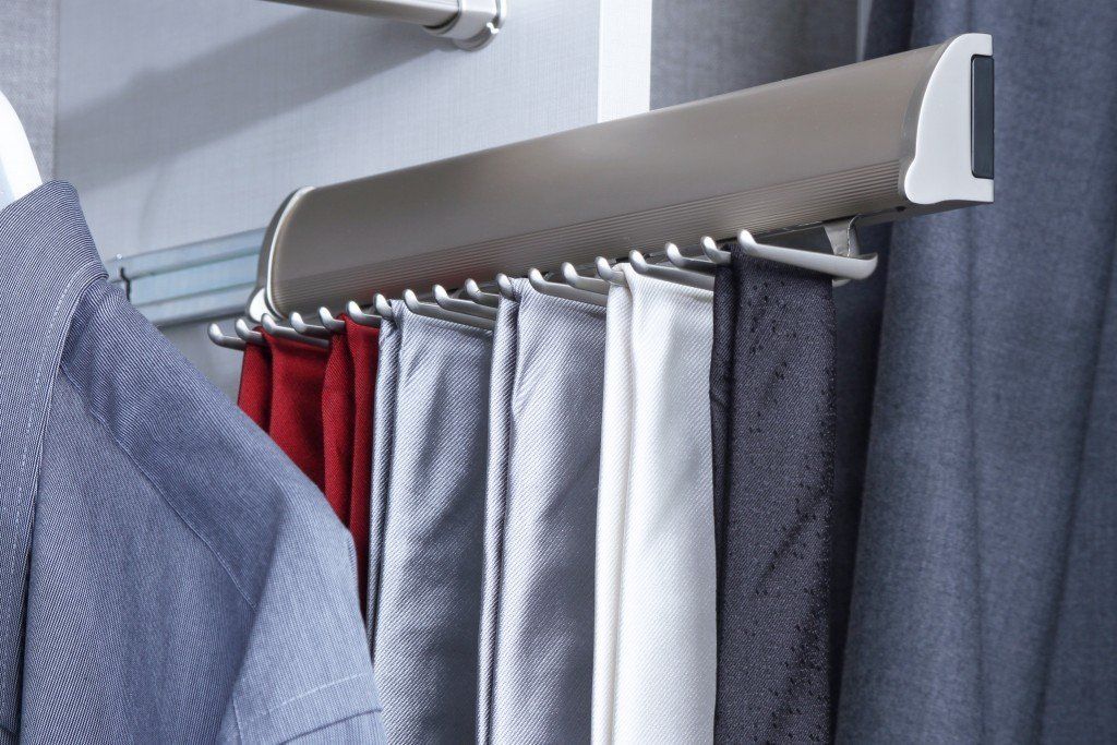 A bunch of clothes are hanging on a rack in a closet