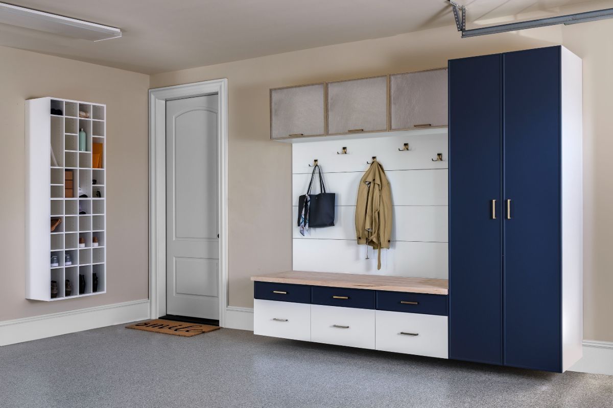 A garage with blue and white cabinets and a bench.