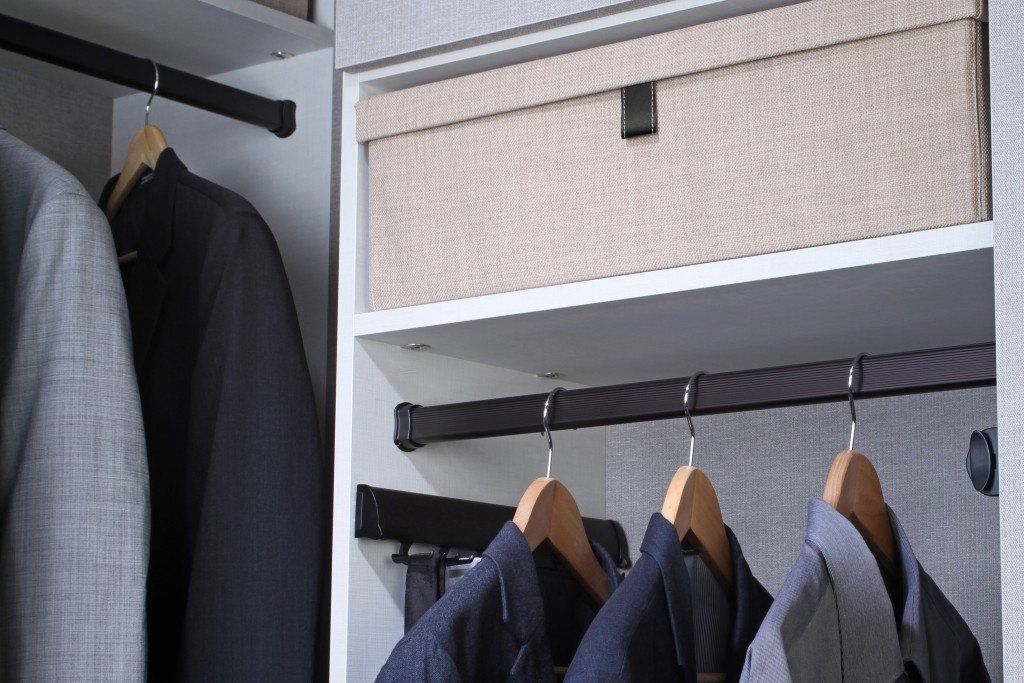 A closet filled with clothes and a box.