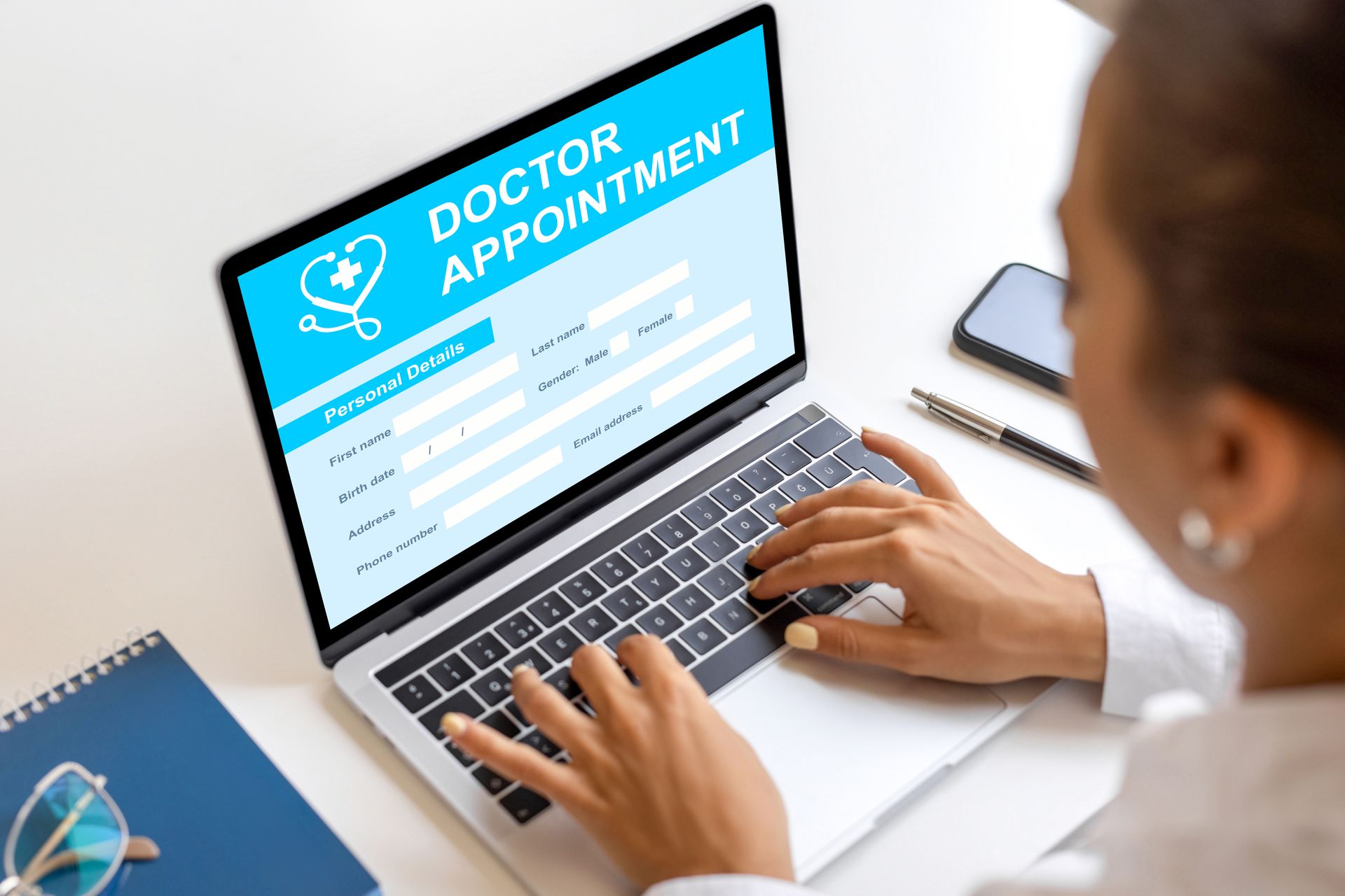 A woman is using a laptop computer to fill out a doctor appointment form.