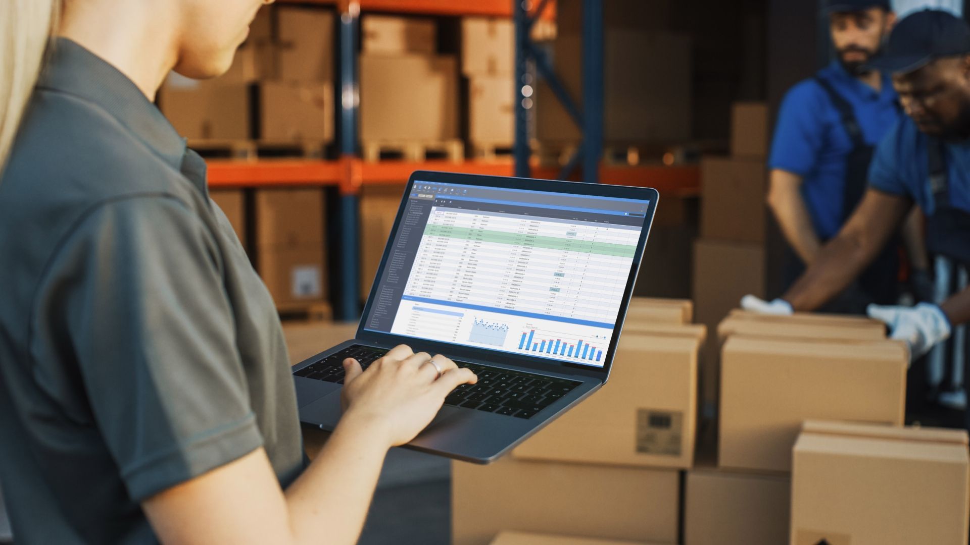 A woman is using a laptop computer in a warehouse.