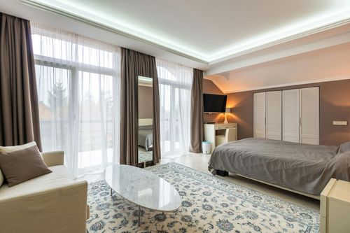 A hotel room with a bed , couch , coffee table and television.