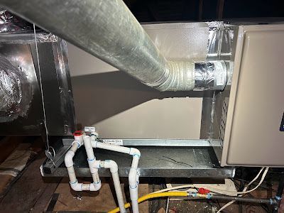 A close up of a ventilation system with pipes and wires.