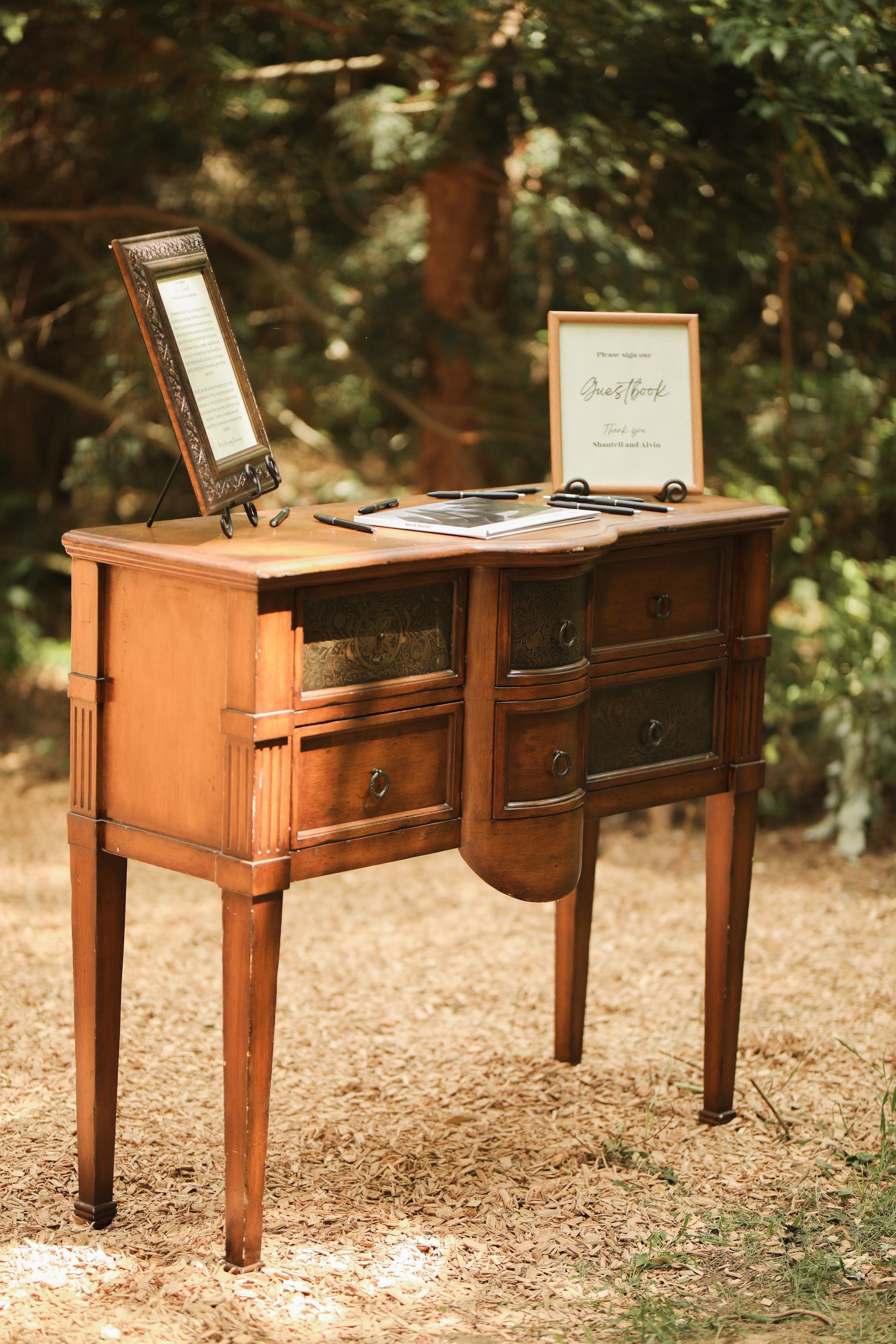 A wooden table with drawers and a mirror on top of it.
