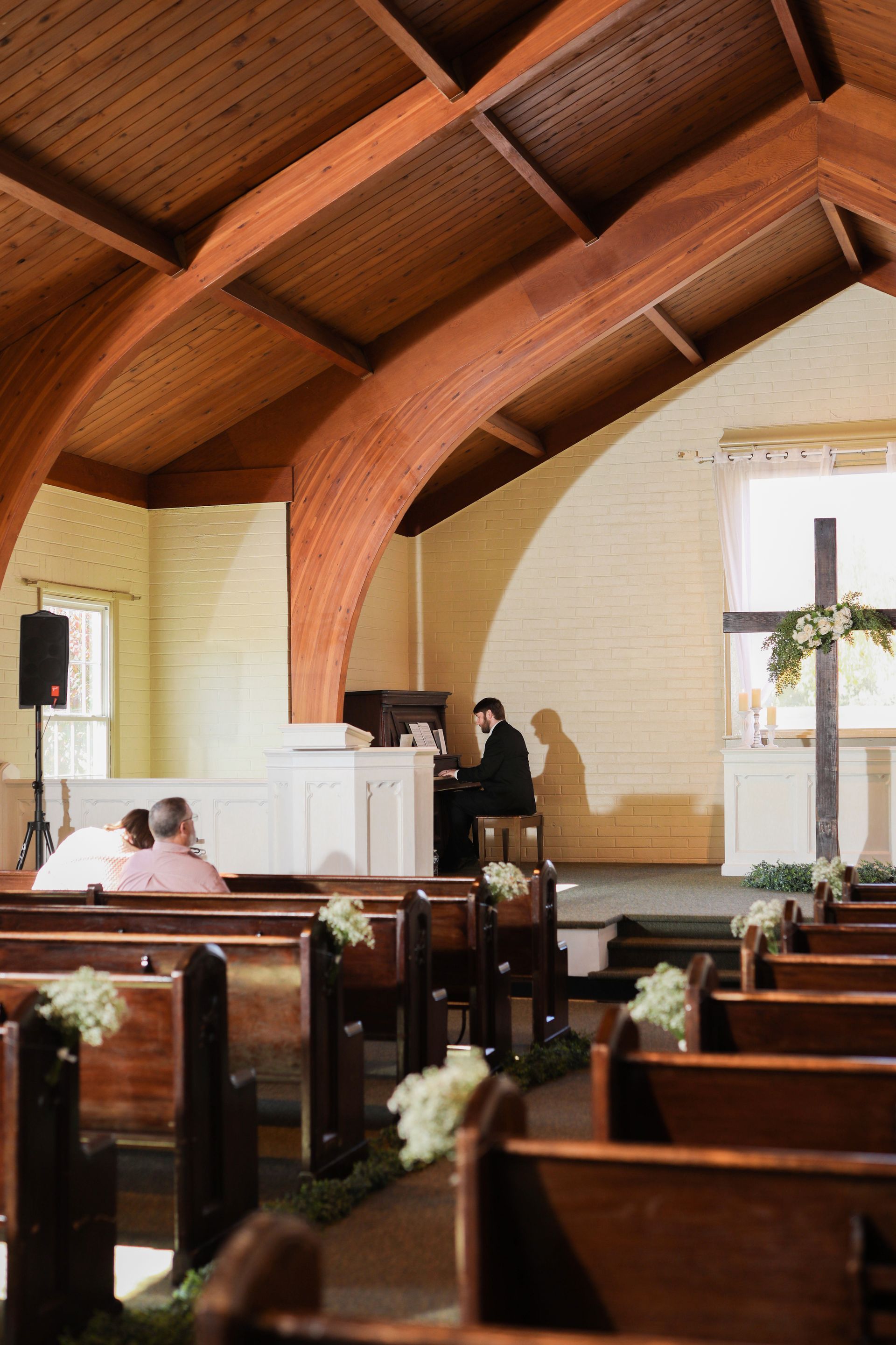 A church with a wooden ceiling and rows of wooden benches