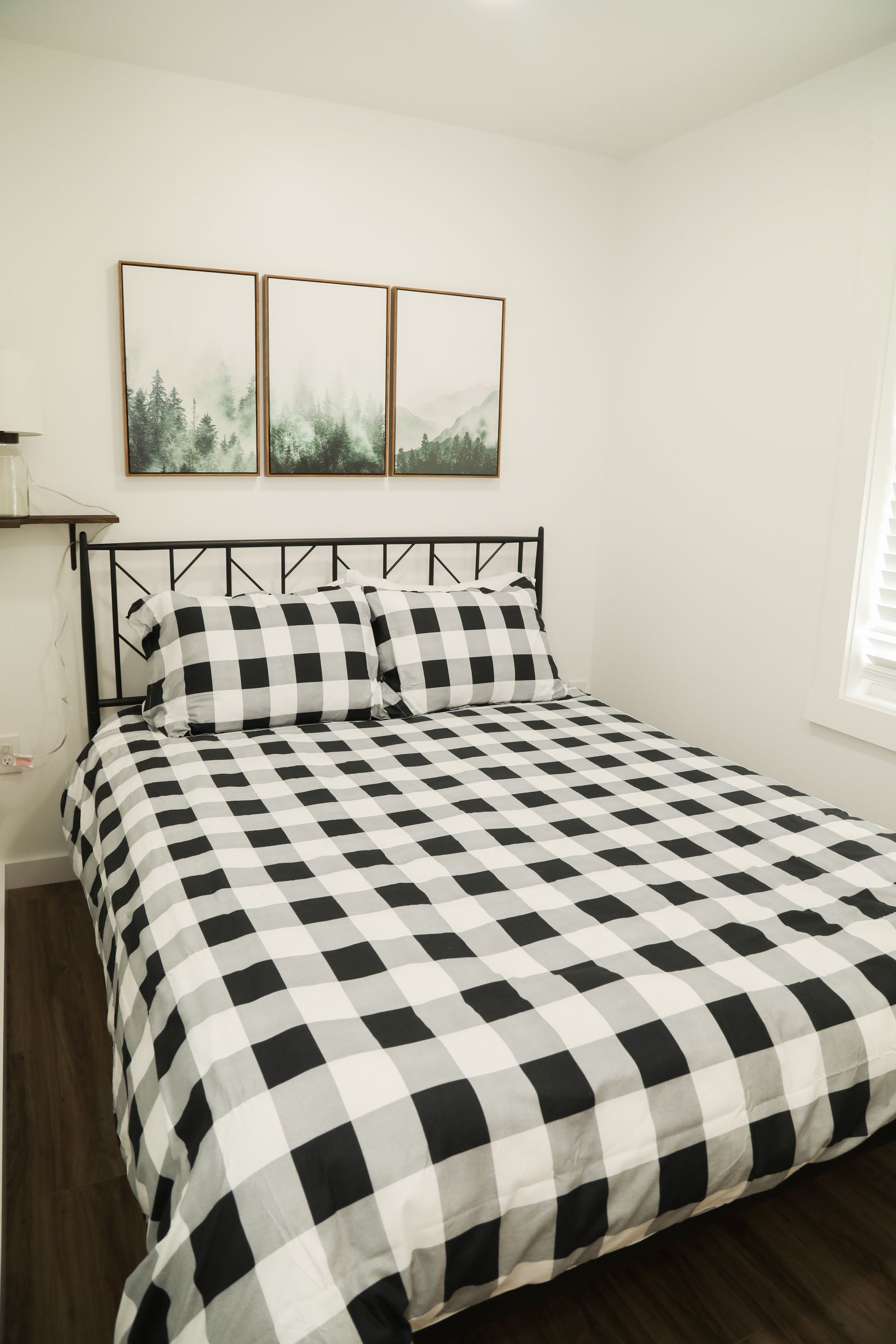 A bed with a black and white checkered comforter and pillows in a bedroom.