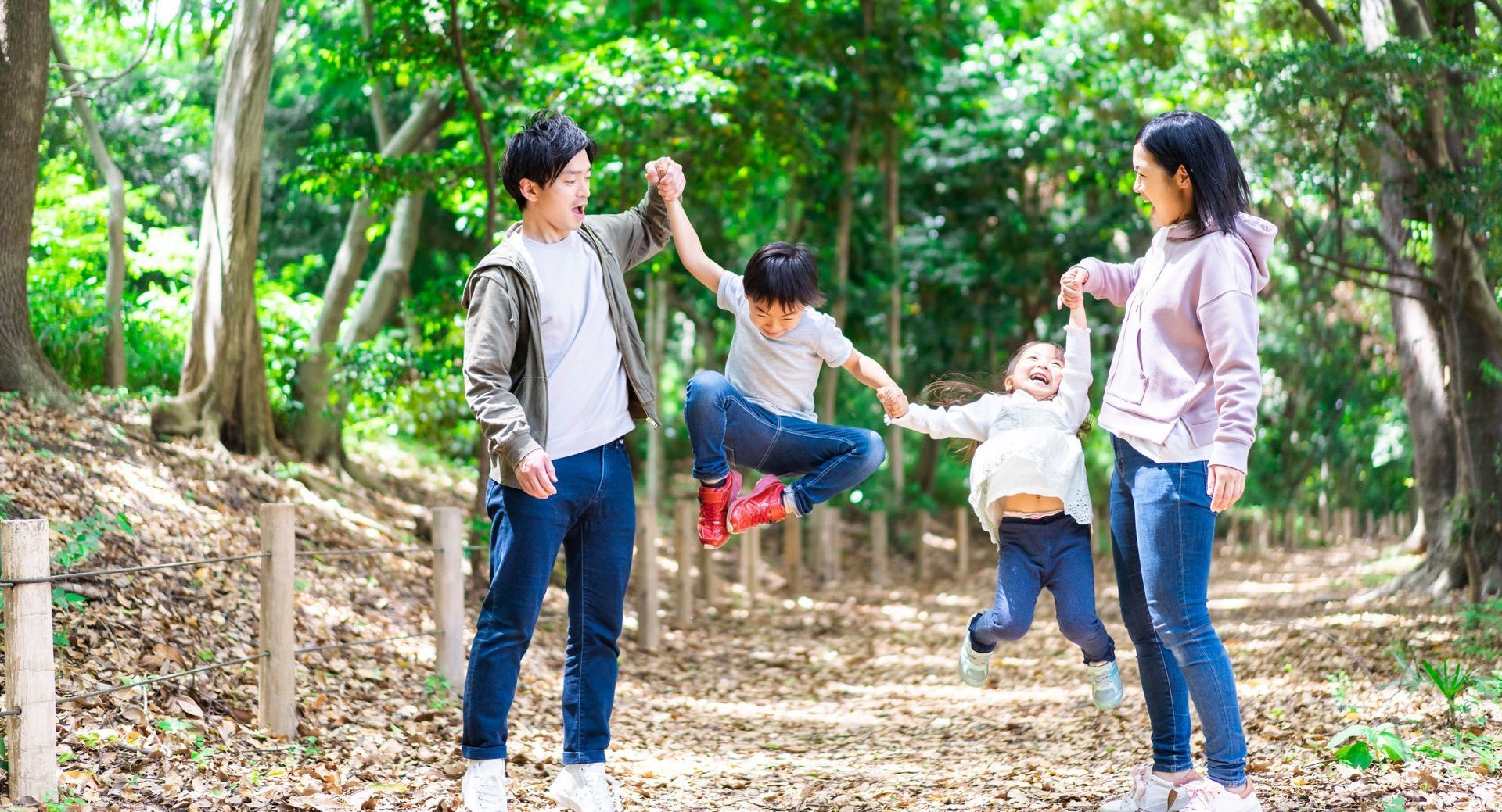 A family is playing in the woods together.