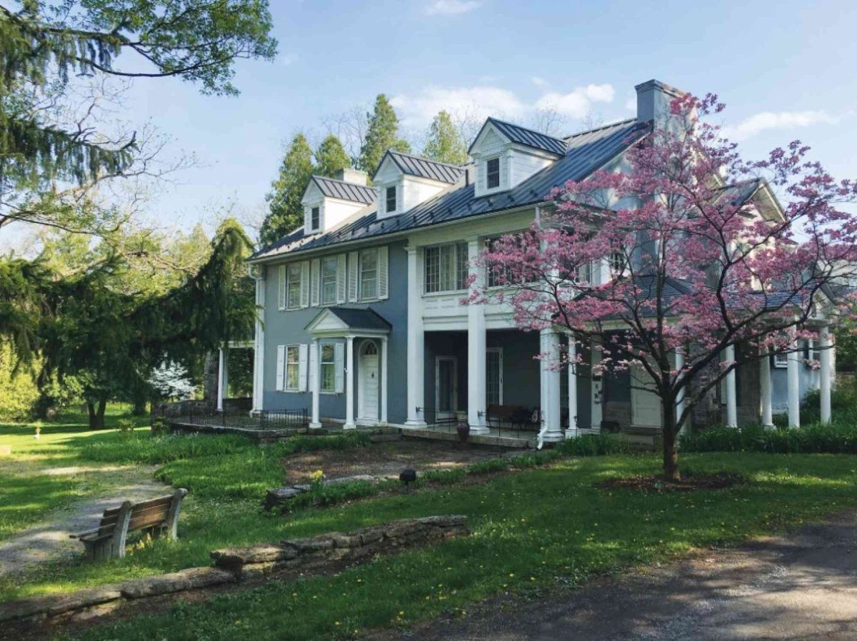 A large house with a lot of windows and a tree in front of it.