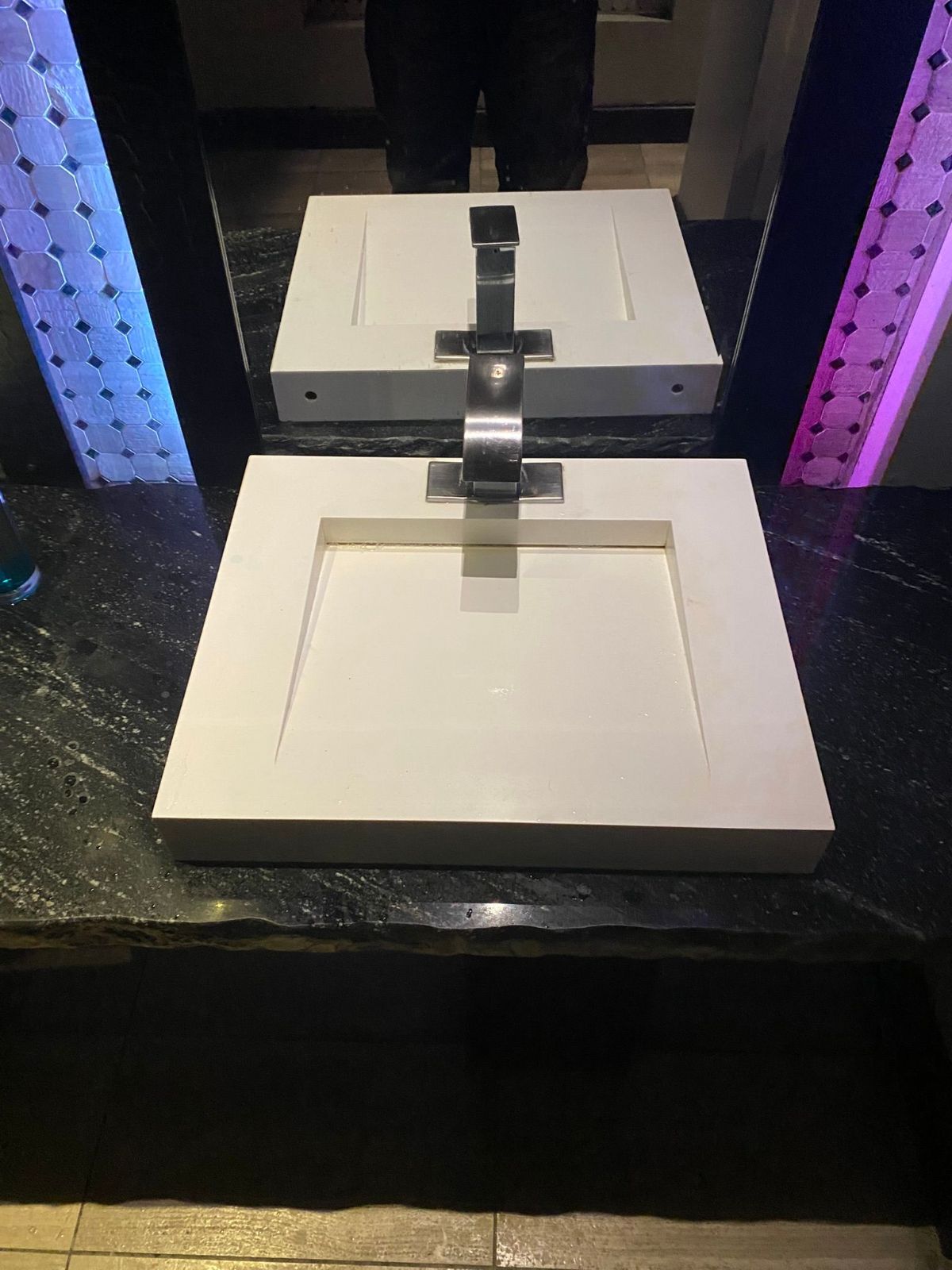 A bathroom sink with a faucet and a mirror