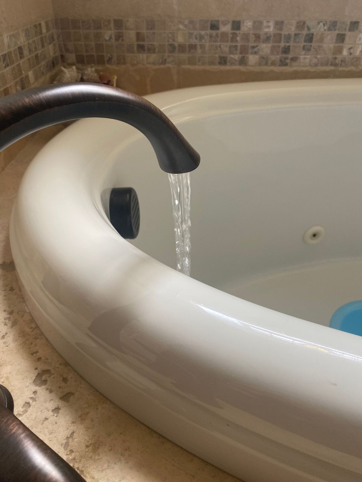A close up of a bathtub with water coming out of the faucet.
