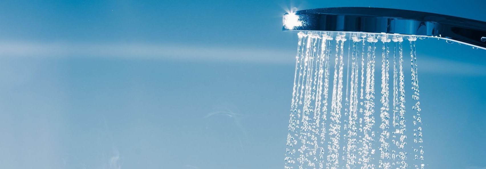 A close up of a shower head with water coming out of it.