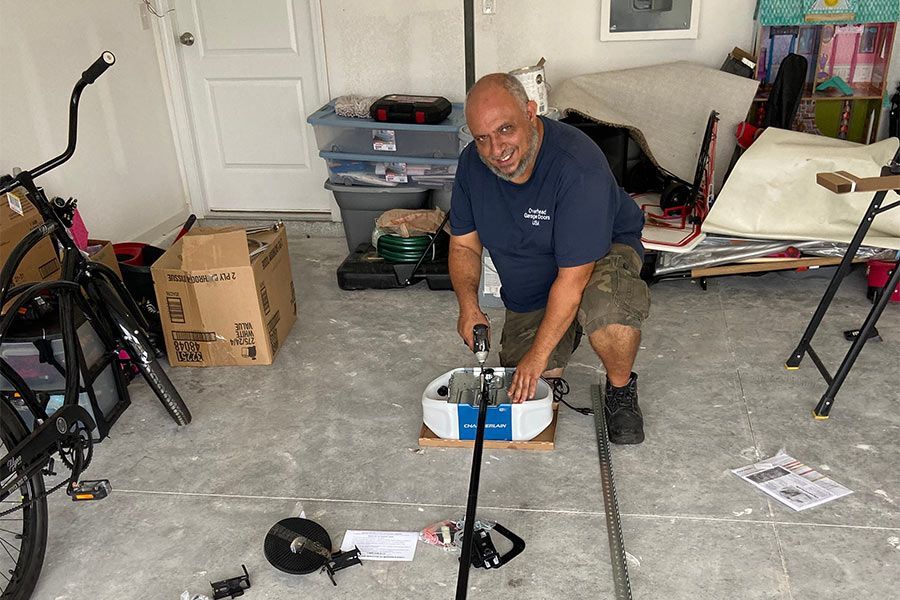 Close-up of garage door hardware: track, springs, and safety cable.