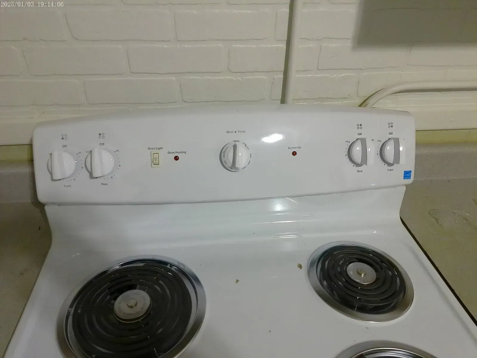 New electric stove installation with visible burner dials and control panel