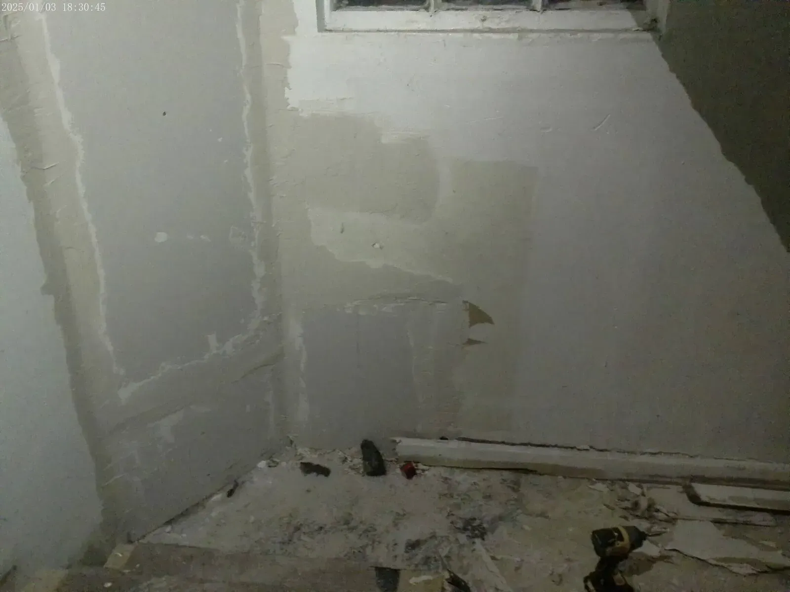 Basement stairwell showing drywall patching and renovation progress