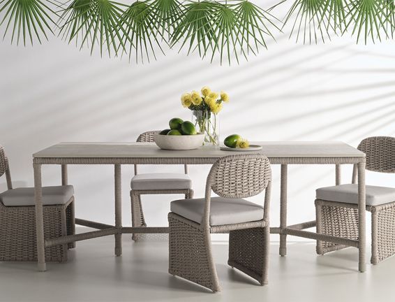 A table and chairs with a bowl of fruit on it