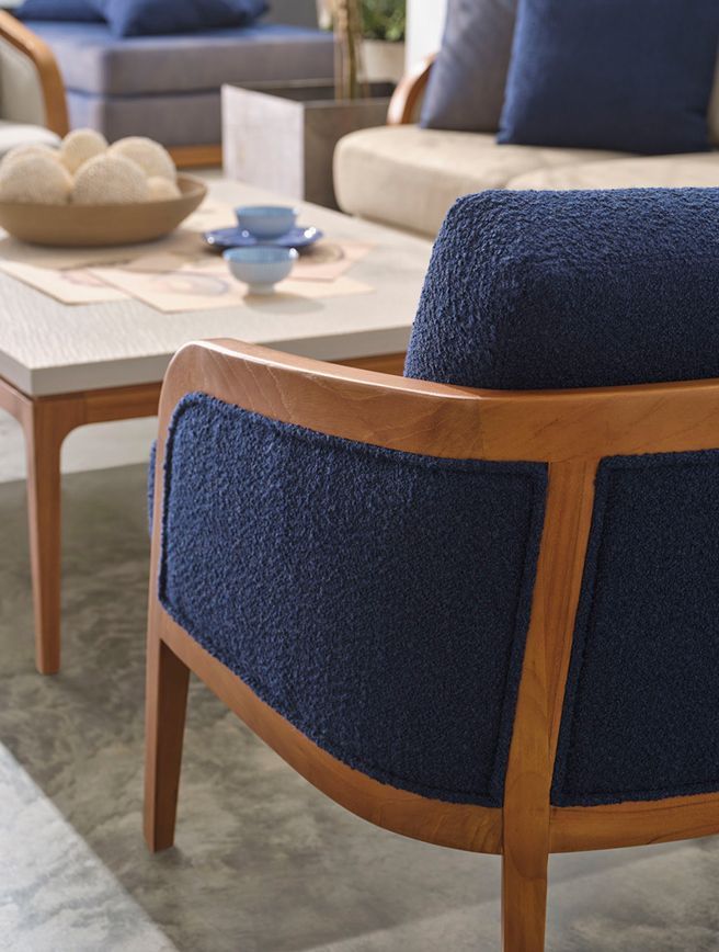 A blue chair in a living room next to a couch