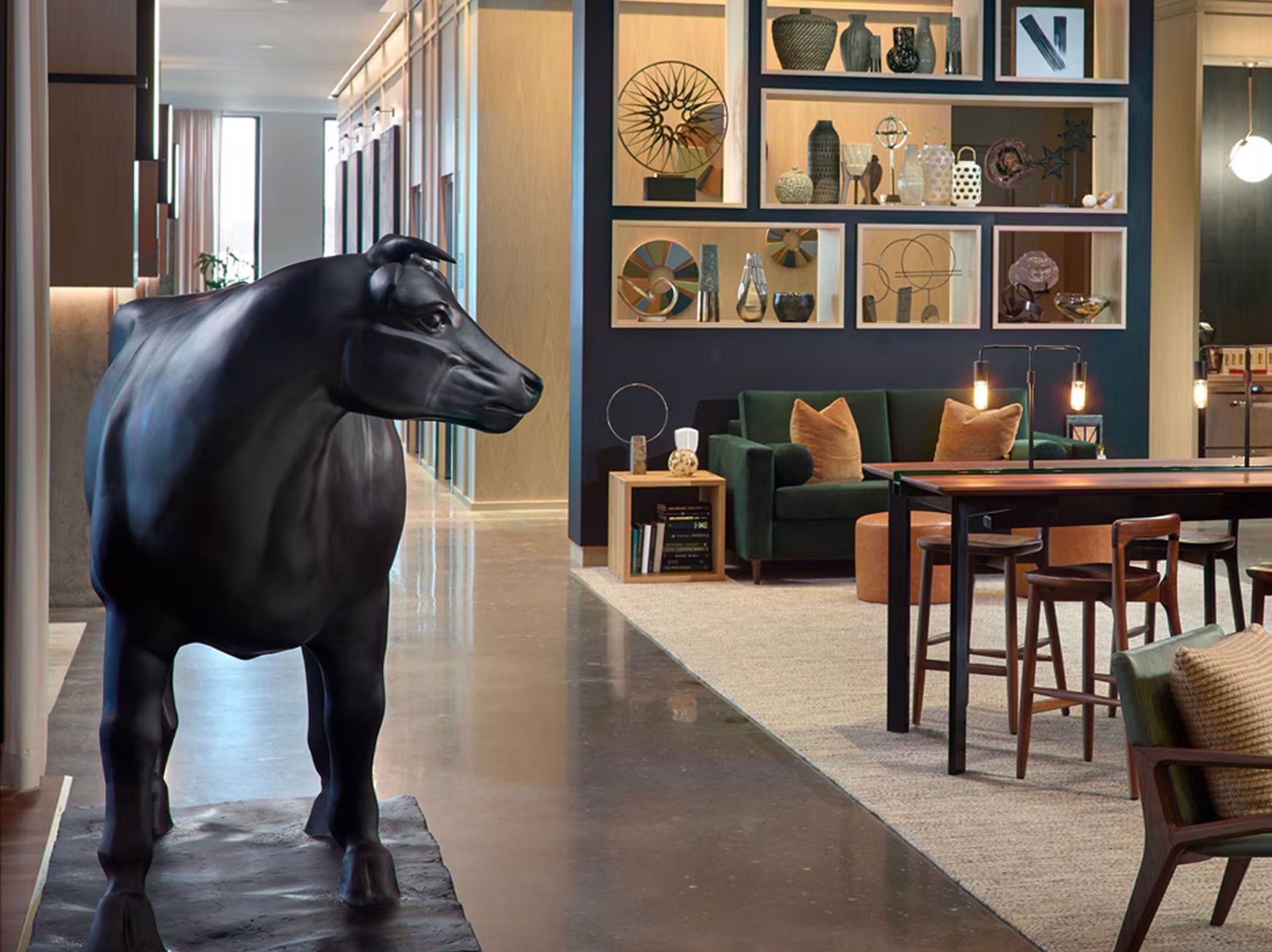 A statue of a cow is standing in a living room.