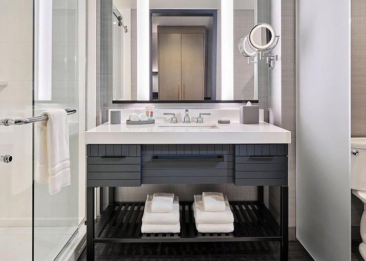A bathroom with a sink , mirror , and towels.