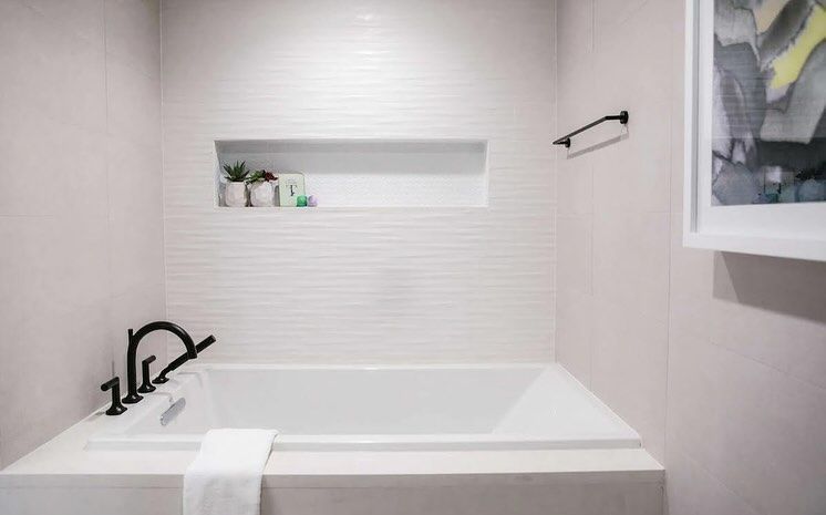 A bathroom with a bathtub and a picture on the wall.