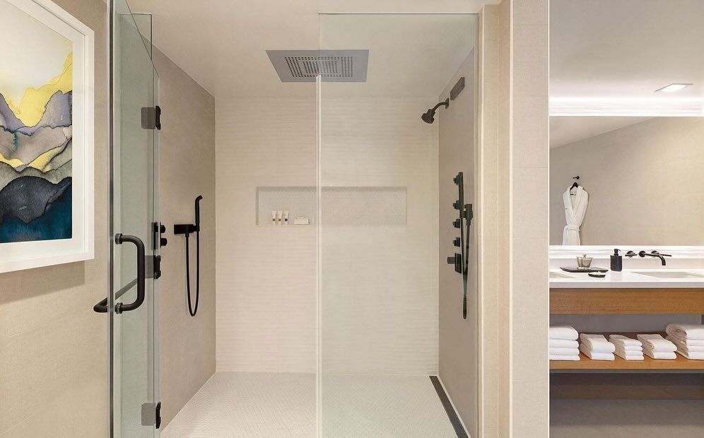 A bathroom with a walk in shower and a sink.