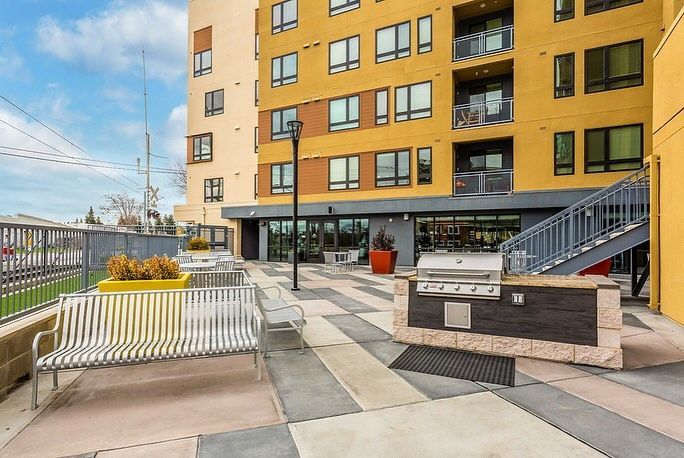 A large yellow building with a grill in front of it.