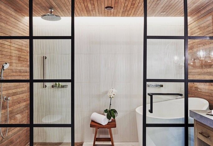 A bathroom with a tub , shower , and wooden ceiling.