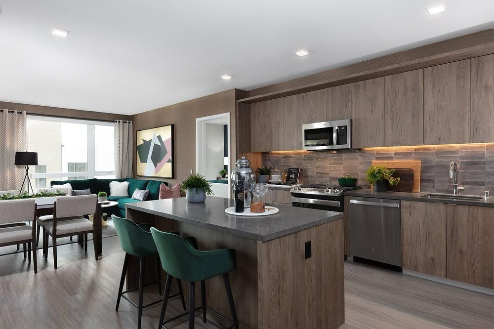 A kitchen with stainless steel appliances , wooden cabinets and a large island.