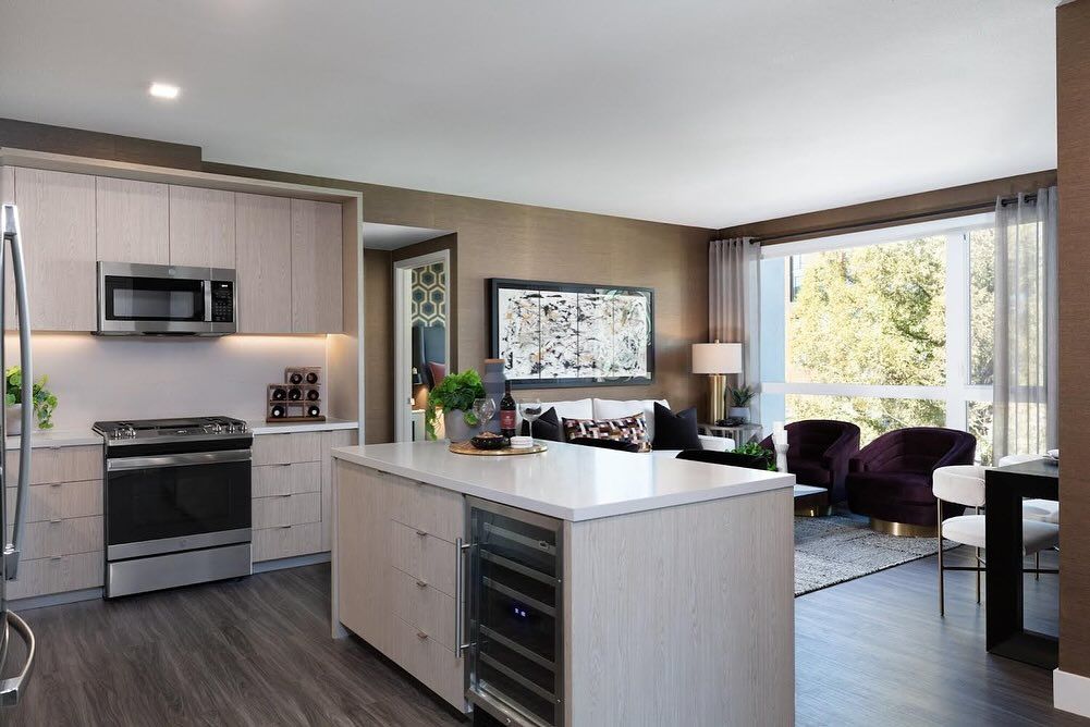 A kitchen with stainless steel appliances and a large island in the middle of the room.