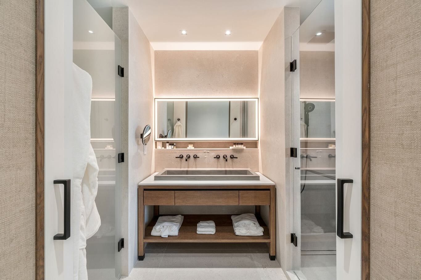 A bathroom with a sink , mirror and shower.