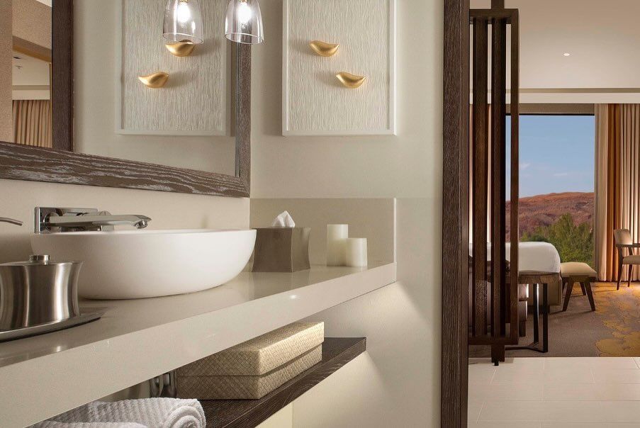 A bathroom in a hotel room with a sink and a mirror.