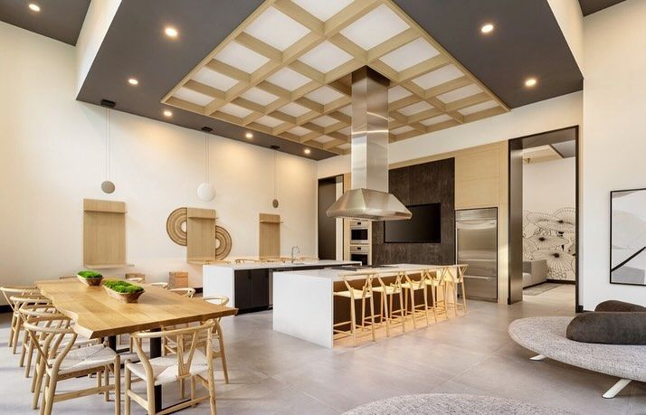 A large room with a dining table and chairs and a kitchen.