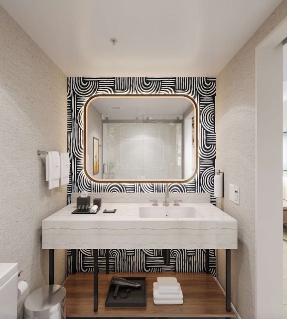 A bathroom with a large mirror and a sink