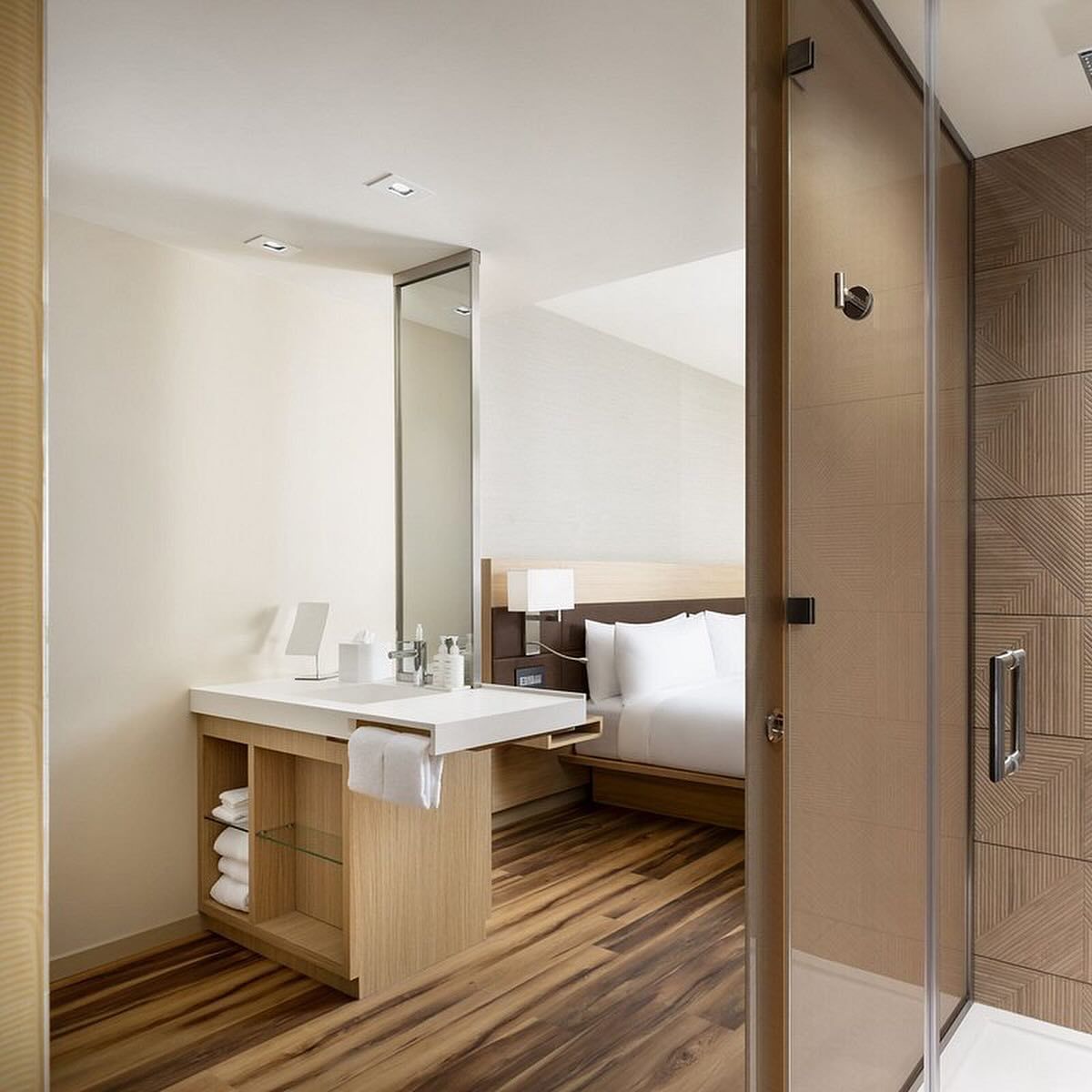 A hotel room with a bathroom and a bed