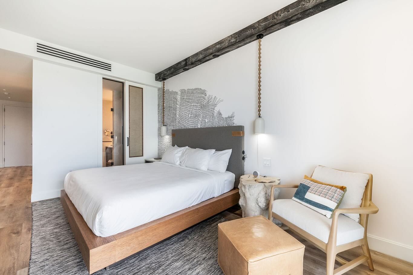 A hotel room with a king size bed and a chair.