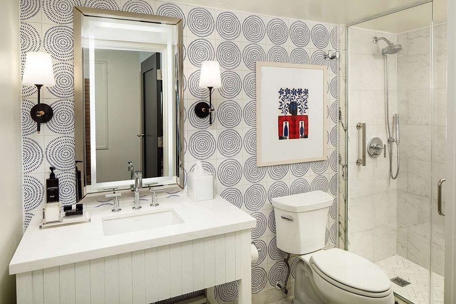 A bathroom with a toilet , sink , mirror and shower.
