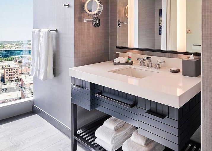 A bathroom with a sink , mirror , and towels.