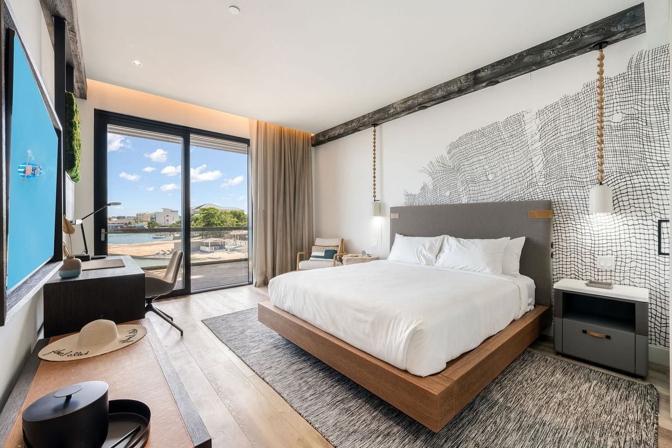 A bedroom with a king size bed and a large window.