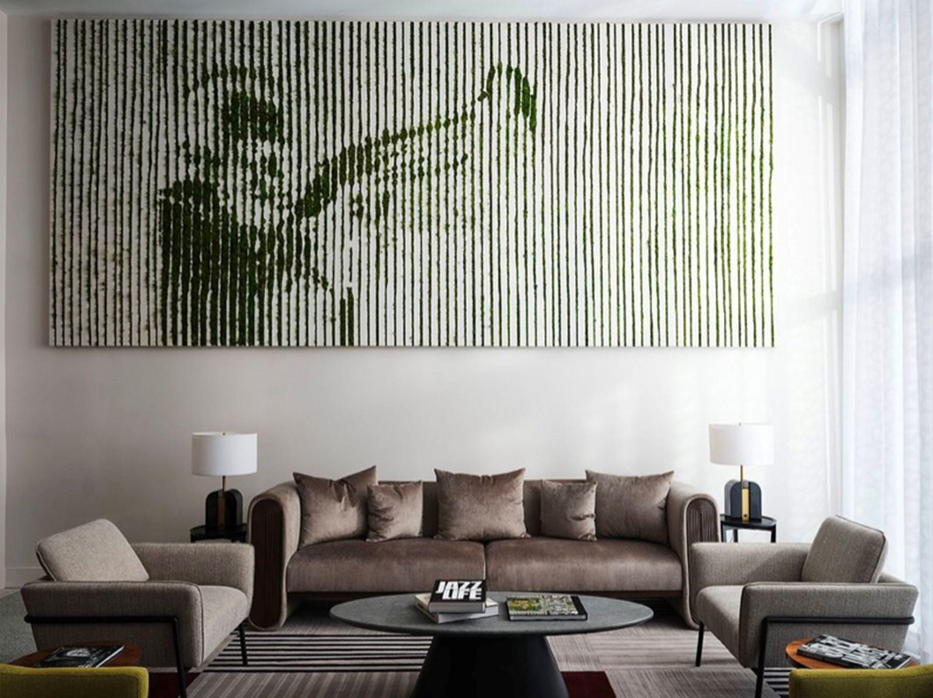 A living room with a couch , chairs , and a large painting on the wall.