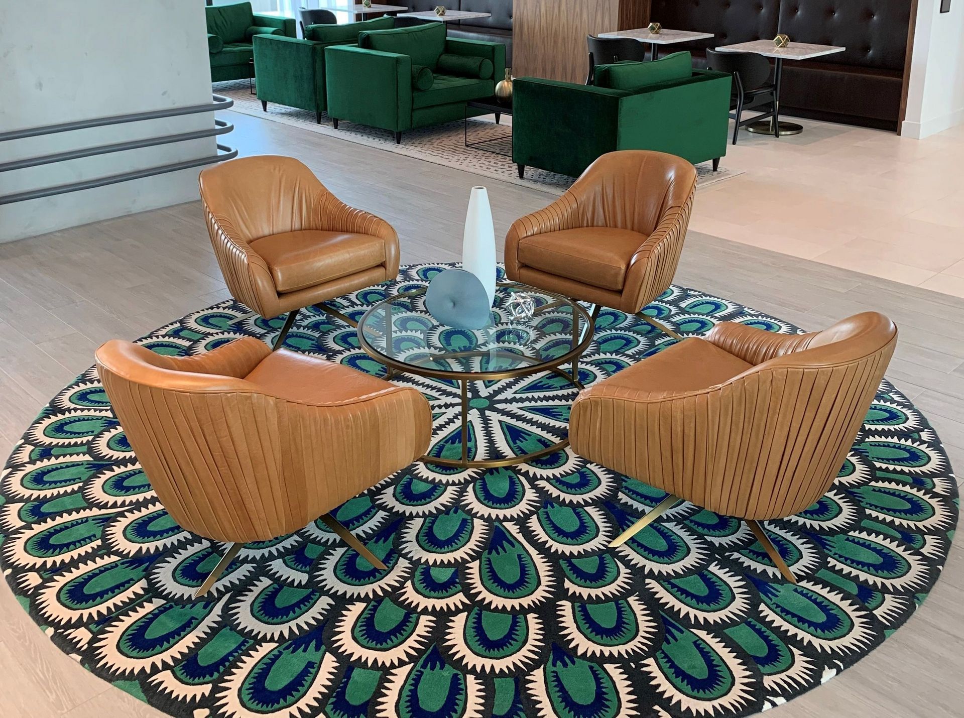 A group of chairs are sitting on a round rug in a living room.