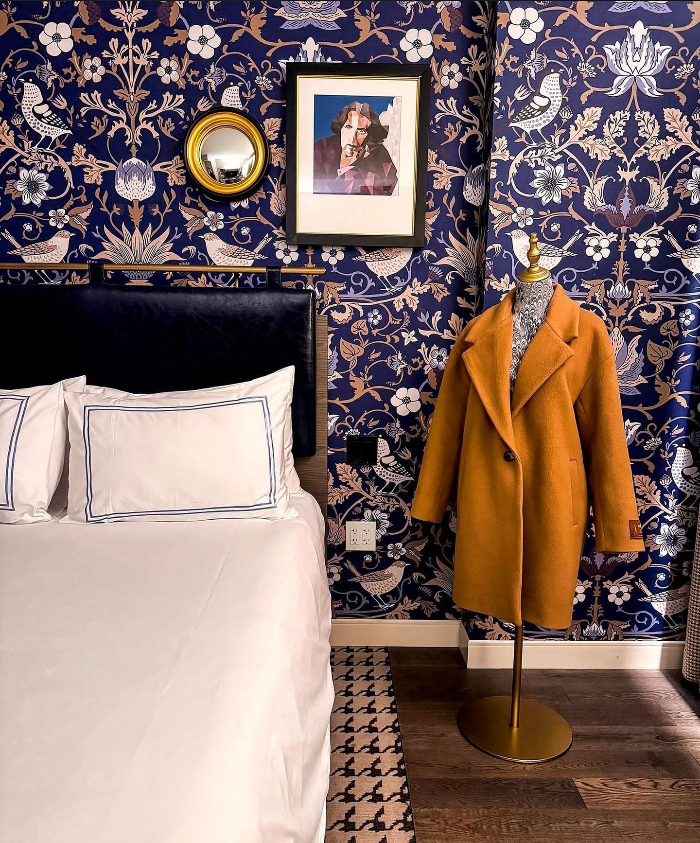 A bedroom with a bed and a coat on a mannequin.