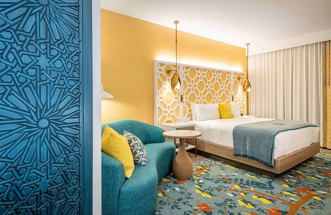 A hotel room with a bed , chair and table.