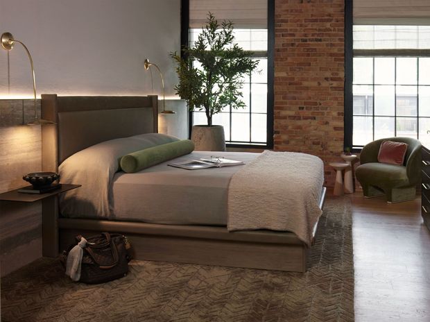 A bedroom with a large bed and a brick wall