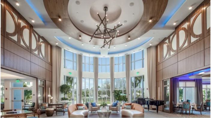 A large living room with a chandelier and lots of windows