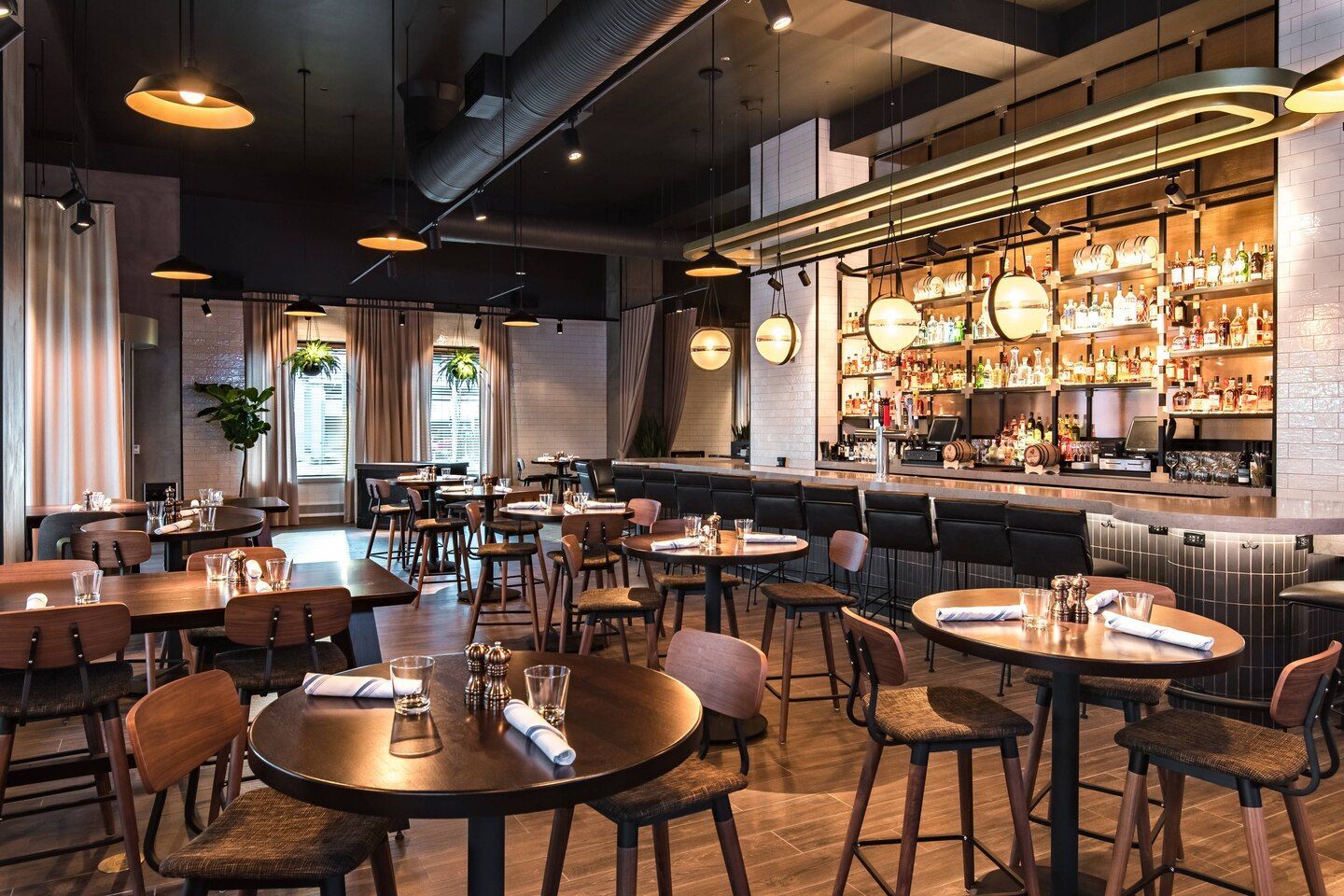 A restaurant filled with tables and chairs and a bar.