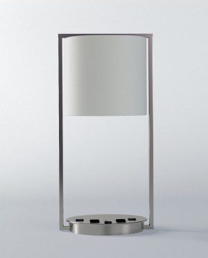 A table lamp with a white shade is sitting on a white surface.