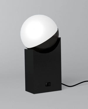 A black lamp with a white ball on top of it