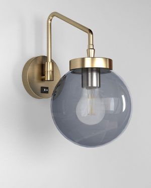A wall light with a gray glass globe on a white wall.